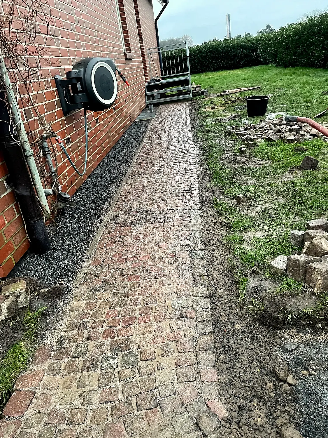 Natursteinweg entlang der Fassade